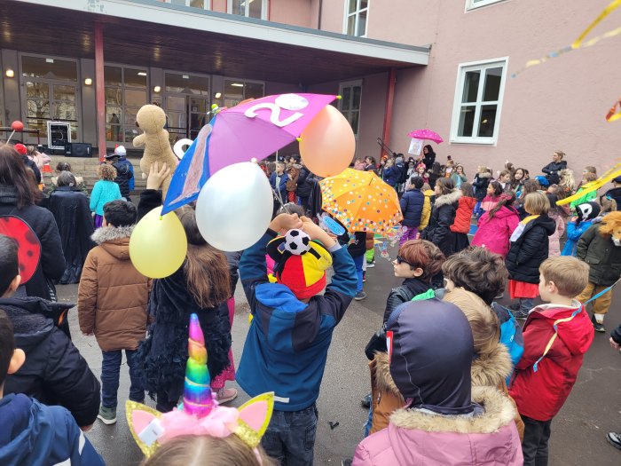 Kinder mit Luftballons in einem Pausenhof